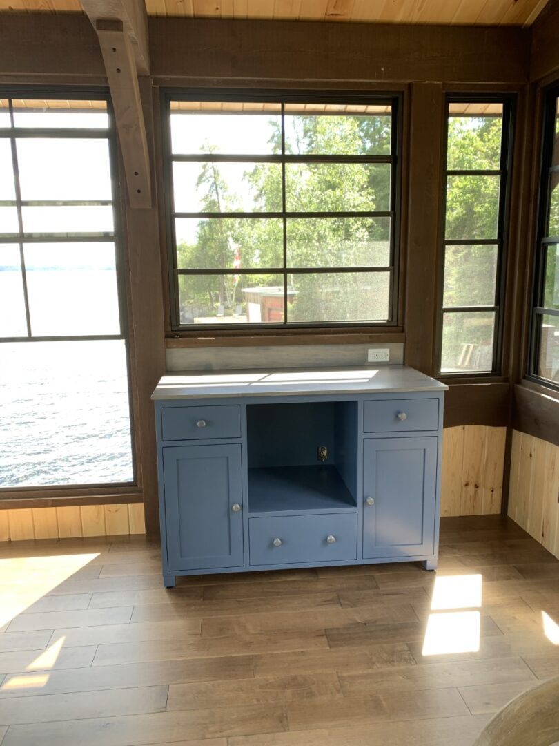 a light blue cabinet by the window